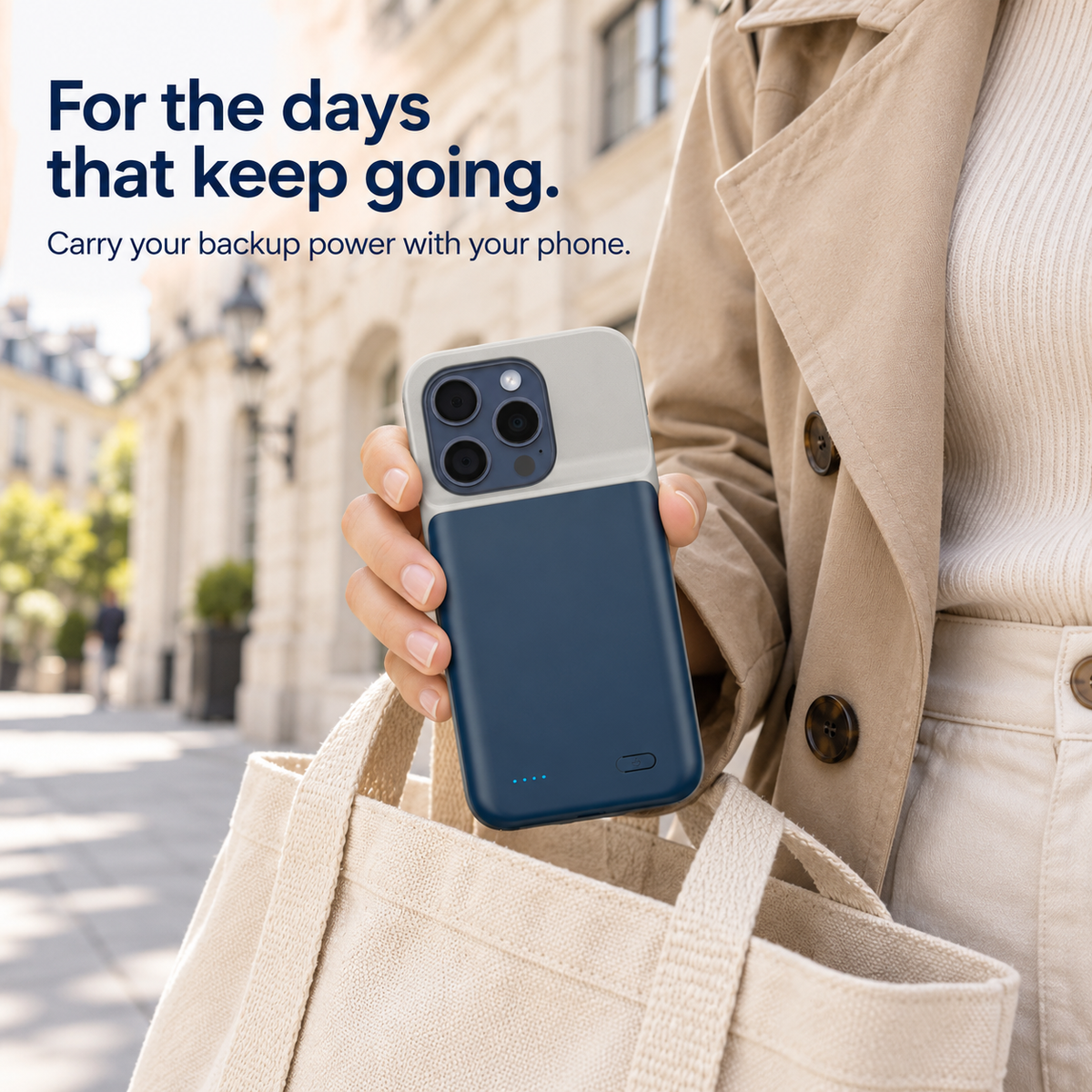 Blue battery phone case carried beside a canvas bag on a city street.